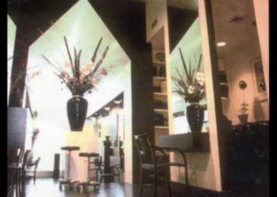 an old-looking shot of a salon with a big black vase with flowers