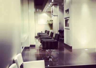 salon with black salon chairs and floor and white walls