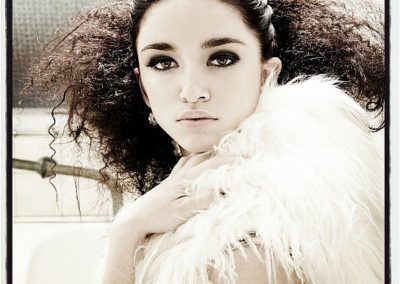 lady with thick curly hair and white fur coat on her shoulders