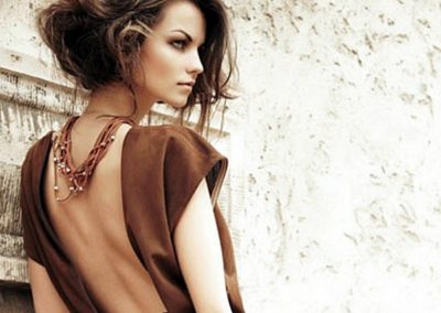 lady with short brown wavy hair wearing a daring brown backless top