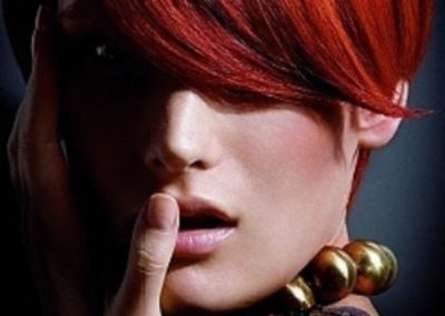 lady with red orange hair touching her face