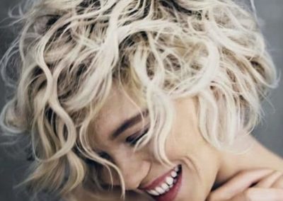 happy lady with short blonde curly hair smiling