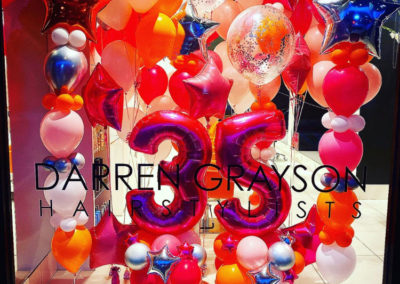 darren grayson salon with lots of colorful balloons